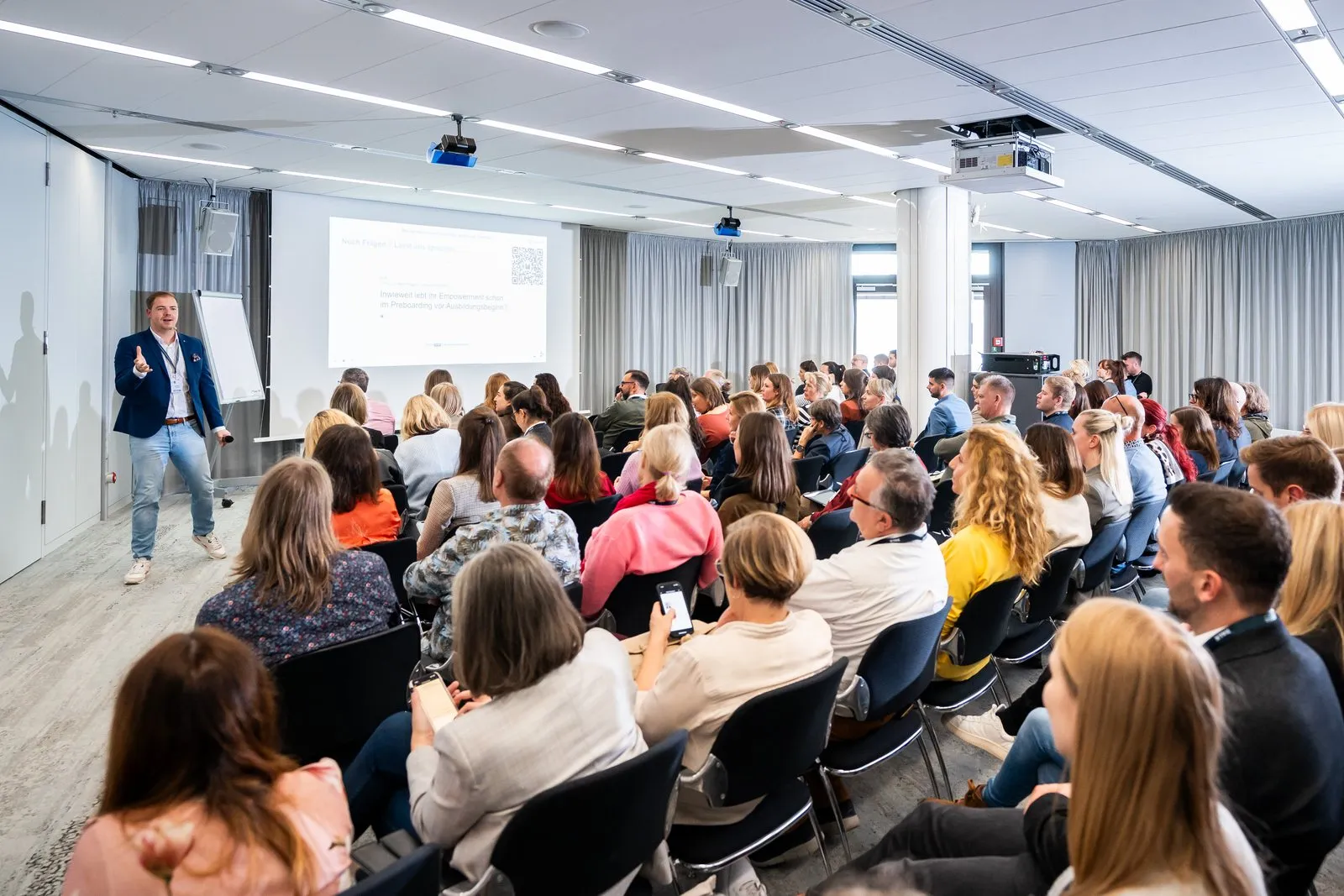 Jan Achnitz auf der Bühne des Deutschen Ausbildungsleiterkongresses 2024 vor vollem Saal