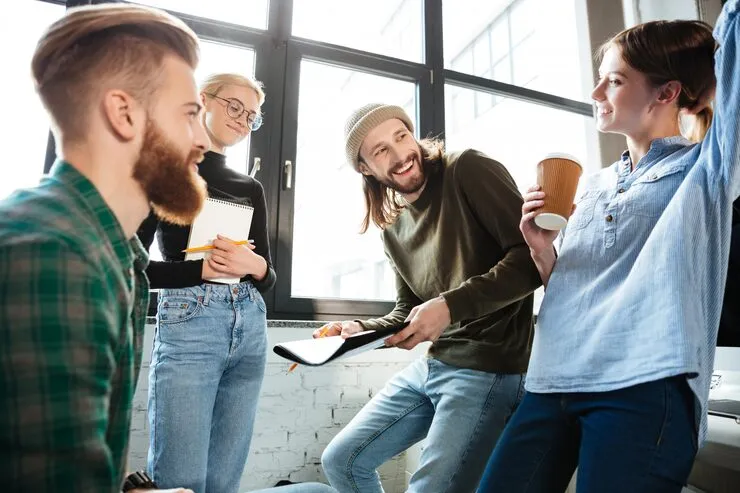 Kolleginnen und Kollegen im lockeren Austausch im Büro